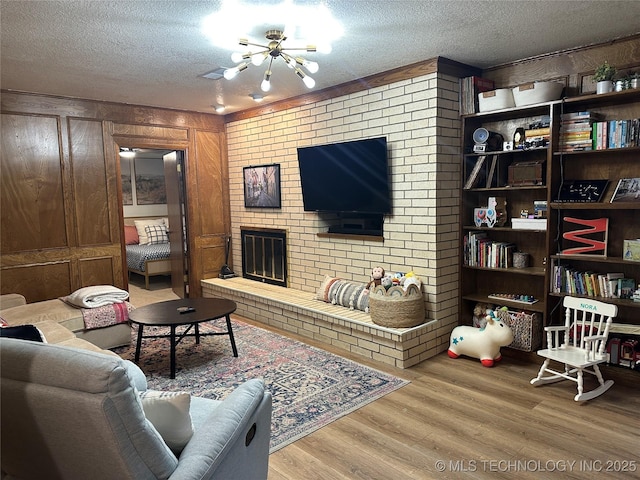 2621 Chuckwa St, Durant, OK 74701 - living area with a chandelier, a textured ceiling, wood finished floors, and a fireplace