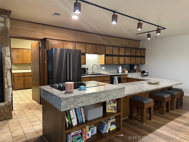 2621 Chuckwa St, Durant, OK 74701 - kitchen with black appliances, open shelves, a sink, track lighting, and a breakfast bar