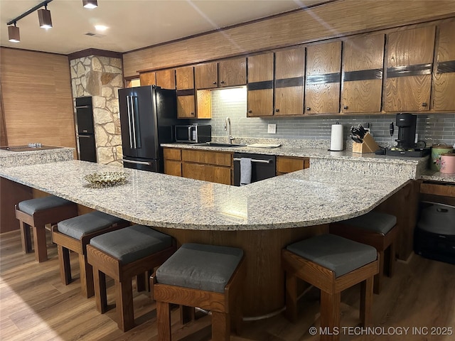 2621 Chuckwa St, Durant, OK 74701 - kitchen with black appliances, brown cabinetry, a sink, and light wood-style flooring