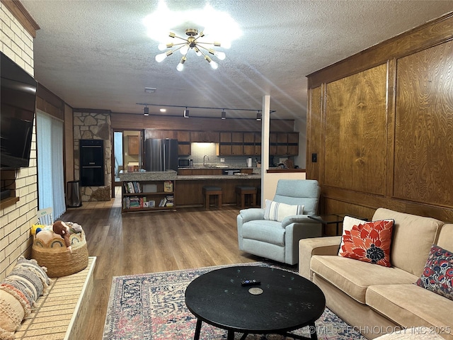 2621 Chuckwa St, Durant, OK 74701 - living room featuring a chandelier, light wood-style flooring, and a textured ceiling