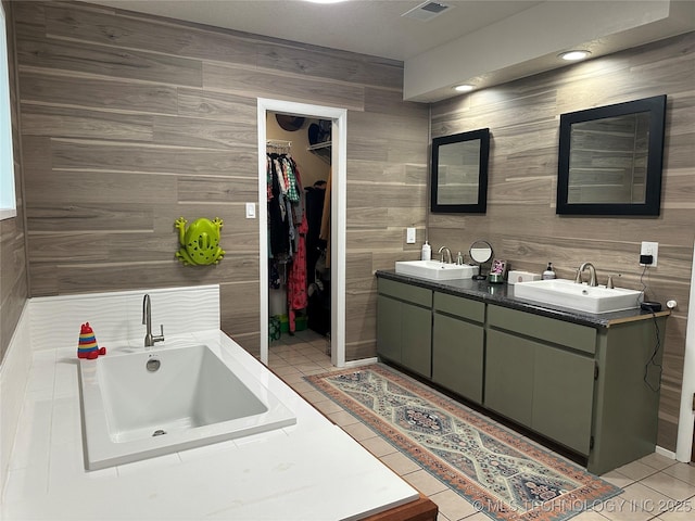 2621 Chuckwa St, Durant, OK 74701 - full bathroom featuring tile patterned floors, a spacious closet, a bathtub, double vanity, and wood walls