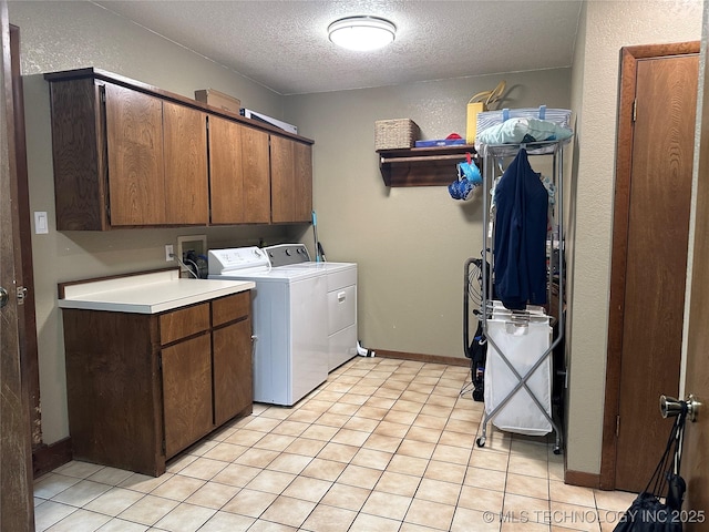 2621 Chuckwa St, Durant, OK 74701 - laundry room featuring cabinet space, washing machine and clothes dryer, a textured ceiling, baseboards, and light tile patterned floors