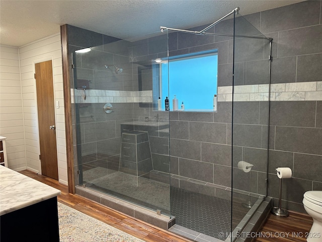 2621 Chuckwa St, Durant, OK 74701 - bathroom with wood finished floors, vanity, toilet, a stall shower, and a textured ceiling