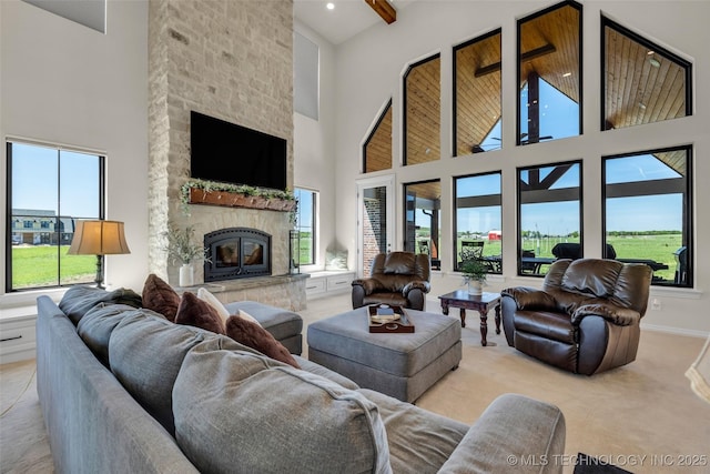5393 W 184th St S, Mounds, OK 74047 - living area with a towering ceiling, a stone fireplace, light colored carpet, and plenty of natural light