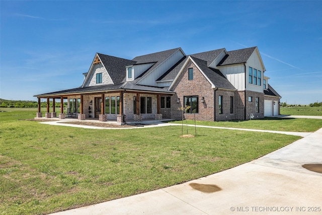 5393 W 184th St S, Mounds, OK 74047 - view of front facade with a front yard, board and batten siding, brick siding, and an attached garage