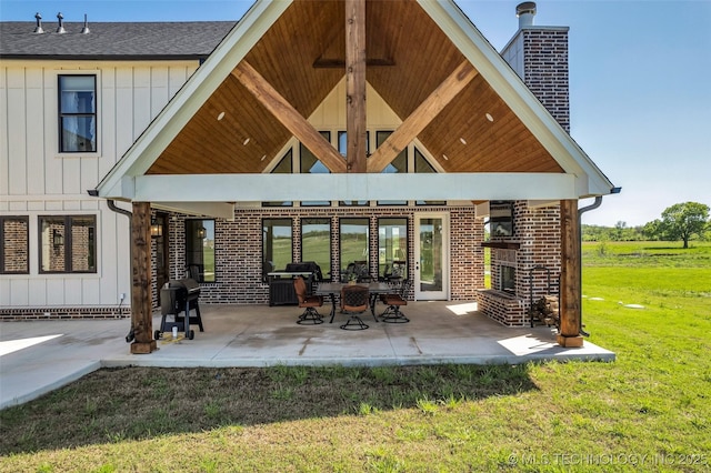 5393 W 184th St S, Mounds, OK 74047 - back of house featuring a chimney, board and batten siding, a yard, a shingled roof, and a patio