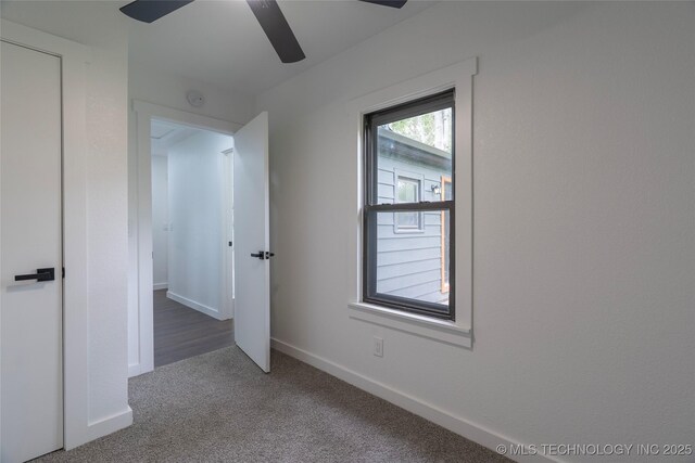 carpeted empty room with baseboards and ceiling fan