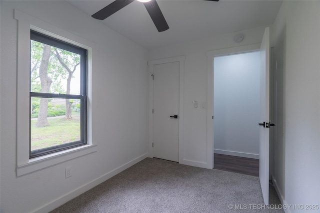 unfurnished bedroom featuring baseboards, a ceiling fan, and carpet