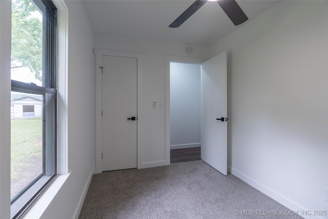 unfurnished bedroom with baseboards, a ceiling fan, and carpet flooring