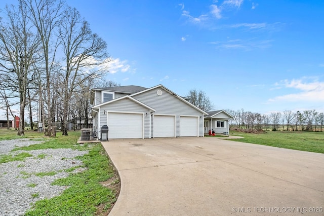 view of side of property featuring a lawn, driveway, and an attached garage