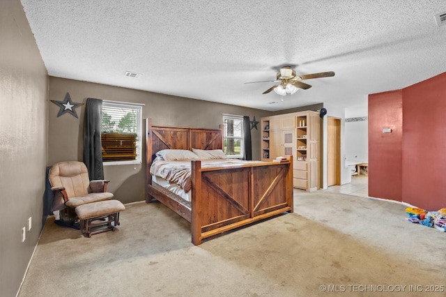 bedroom with light colored carpet, visible vents, a ceiling fan, and multiple windows