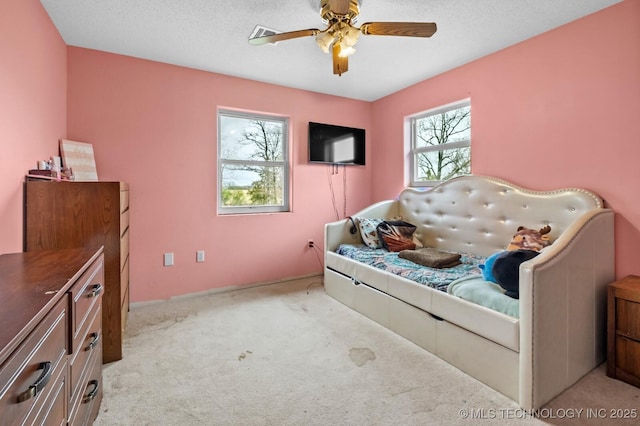bedroom featuring visible vents, a ceiling fan, baseboards, and light carpet