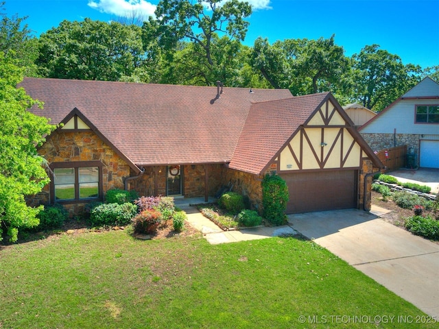 english style home featuring a front yard, driveway, stone siding, and a garage