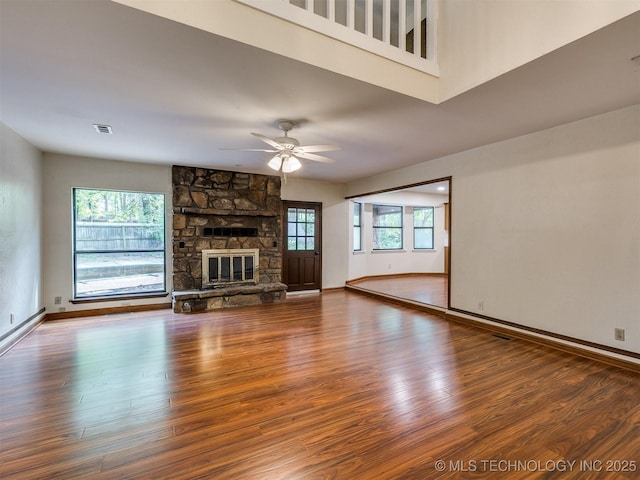 unfurnished living room featuring visible vents, wood finished floors, and plenty of natural light