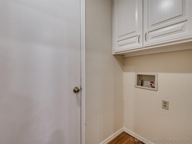 laundry room featuring hookup for a washing machine, wood finished floors, cabinet space, and baseboards