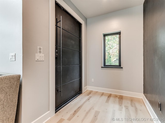 foyer featuring baseboards and light wood-style floors