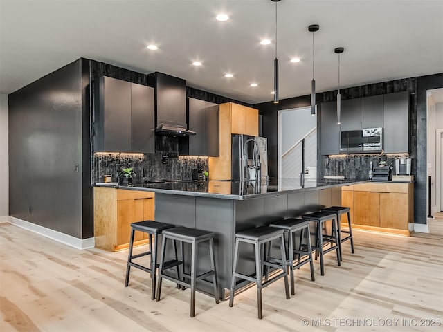 kitchen with modern cabinets, tasteful backsplash, light wood-type flooring, a breakfast bar, and dark countertops