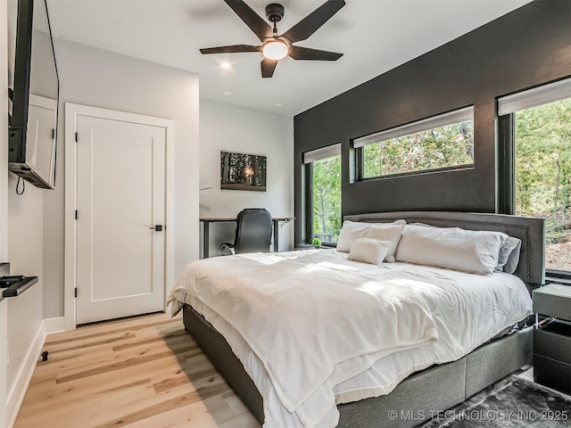 bedroom featuring light wood-style floors, ceiling fan, and baseboards