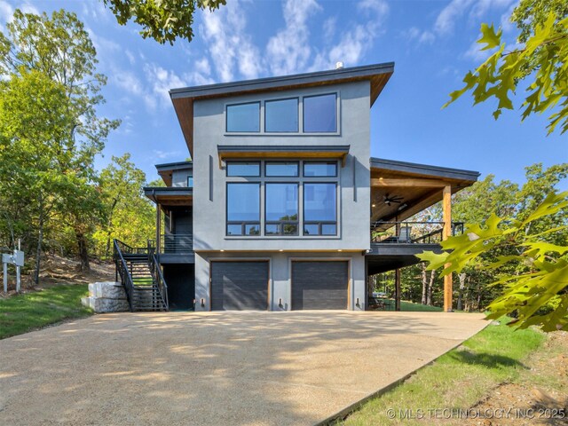view of front of property with stairway, a balcony, stucco siding, concrete driveway, and an attached garage