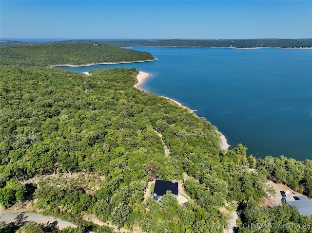 drone / aerial view featuring a water view and a forest view