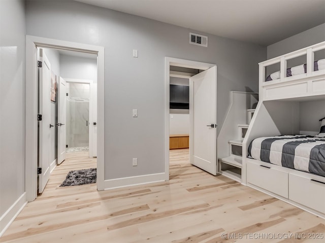 bedroom featuring baseboards, visible vents, and light wood finished floors