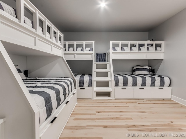 bedroom with light wood finished floors and baseboards