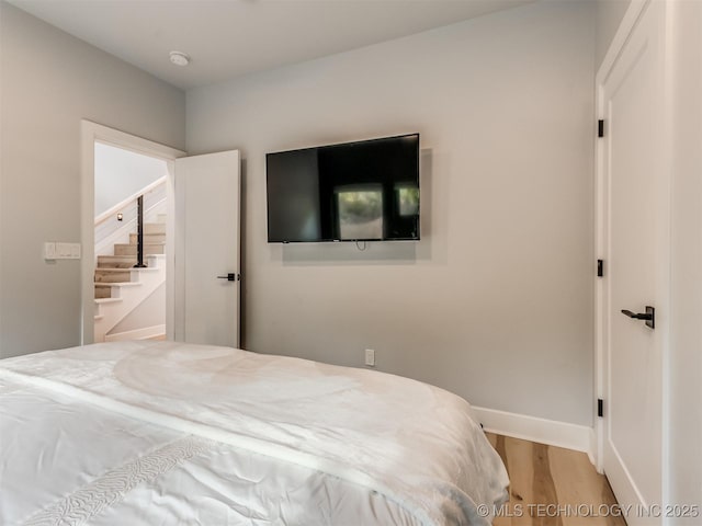 bedroom with baseboards and wood finished floors