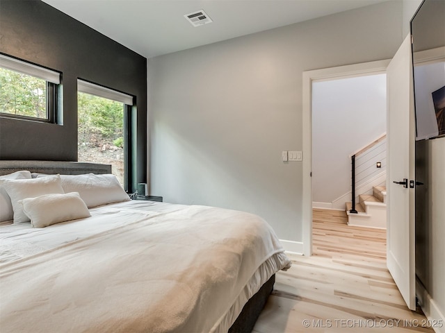 bedroom featuring visible vents, baseboards, and light wood-type flooring