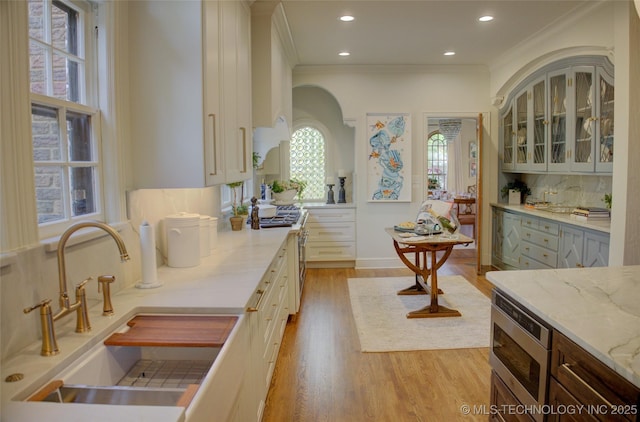 2156 S Owasso Pl, Tulsa, OK 74114 - kitchen featuring backsplash, ornamental molding, plenty of natural light, and a sink
