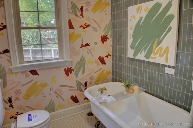 2156 S Owasso Pl, Tulsa, OK 74114 - full bathroom featuring a freestanding bath, tile patterned floors, baseboards, toilet, and wallpapered walls