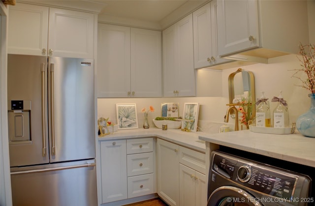 2156 S Owasso Pl, Tulsa, OK 74114 - kitchen featuring high end refrigerator, light stone countertops, washer / clothes dryer, and white cabinetry
