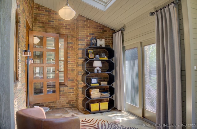 2156 S Owasso Pl, Tulsa, OK 74114 - living area featuring vaulted ceiling with skylight and brick wall