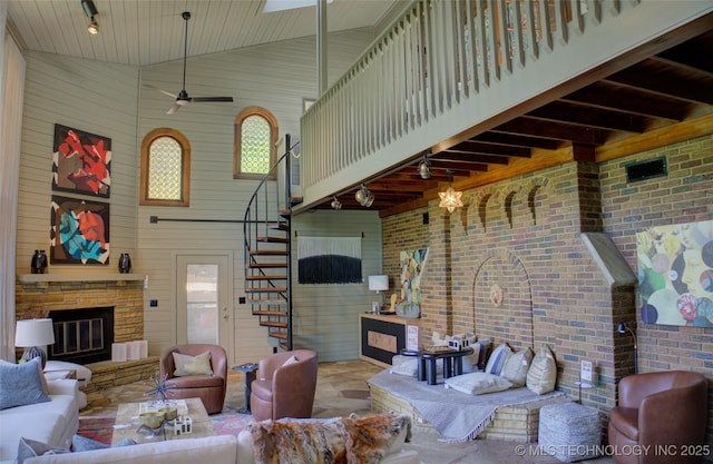 2156 S Owasso Pl, Tulsa, OK 74114 - living room featuring wood walls, stairs, ceiling fan, and a fireplace