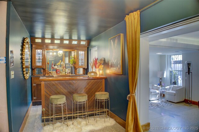 2156 S Owasso Pl, Tulsa, OK 74114 - bar featuring baseboards, freestanding refrigerator, and bar area