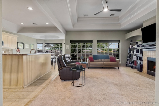 living room featuring visible vents, ornamental molding, ceiling fan, and plenty of natural light