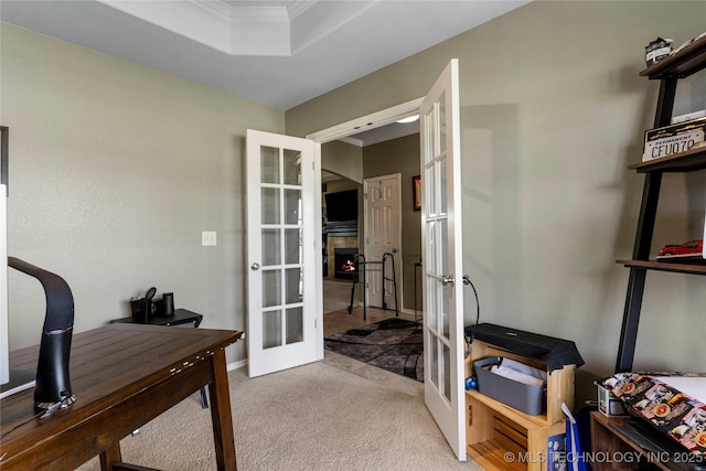 home office featuring a raised ceiling, carpet floors, french doors, and crown molding