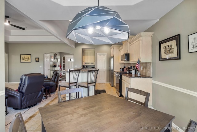 dining room with light tile patterned floors, beamed ceiling, ceiling fan, baseboards, and arched walkways