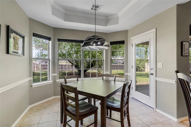 dining area with light tile patterned floors, visible vents, ornamental molding, and a tray ceiling
