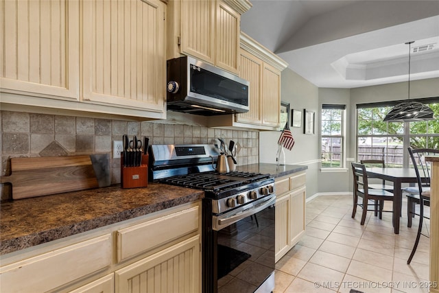 kitchen featuring stainless steel appliances, light tile patterned floors, dark countertops, backsplash, and visible vents