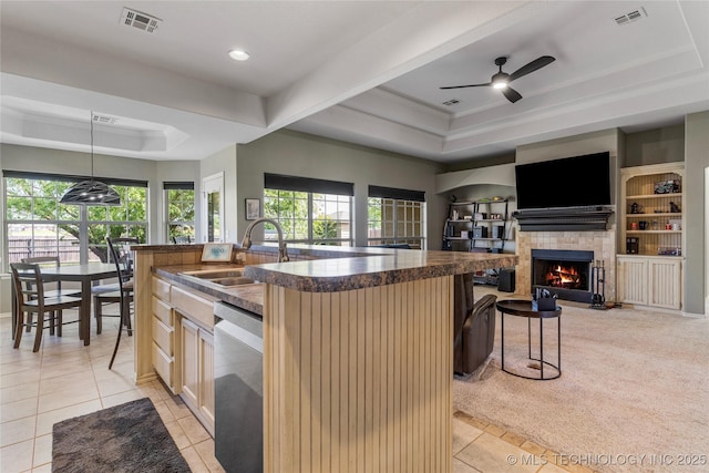 kitchen featuring visible vents, a raised ceiling, dishwasher, and a sink