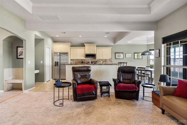 living area featuring crown molding, light colored carpet, visible vents, arched walkways, and recessed lighting