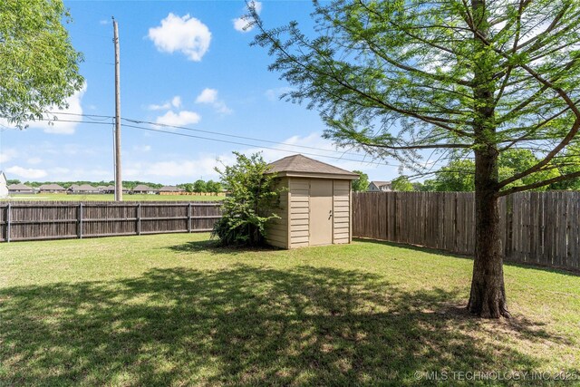 view of yard with an outdoor structure, a storage unit, and a fenced backyard