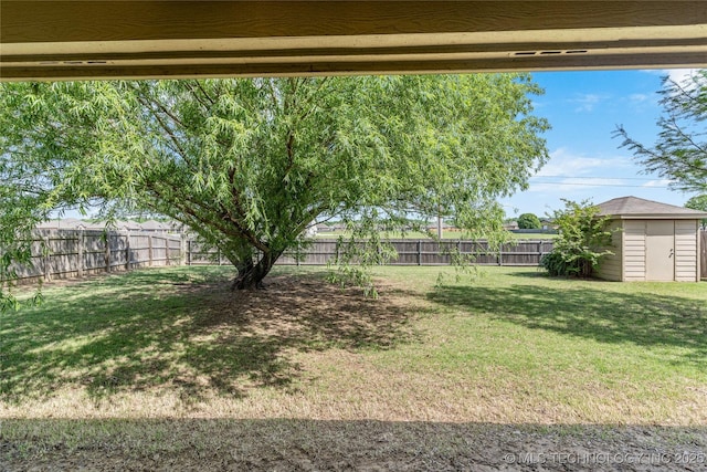 view of yard with an outbuilding, a shed, and a fenced backyard