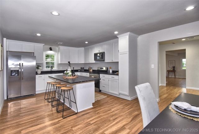543 N Ridgeway St, Sapulpa, OK 74066 - kitchen with appliances with stainless steel finishes, white cabinetry, dark countertops, a breakfast bar area, and recessed lighting