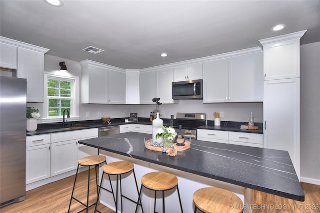 543 N Ridgeway St, Sapulpa, OK 74066 - kitchen featuring stainless steel appliances, white cabinetry, a sink, light wood finished floors, and recessed lighting