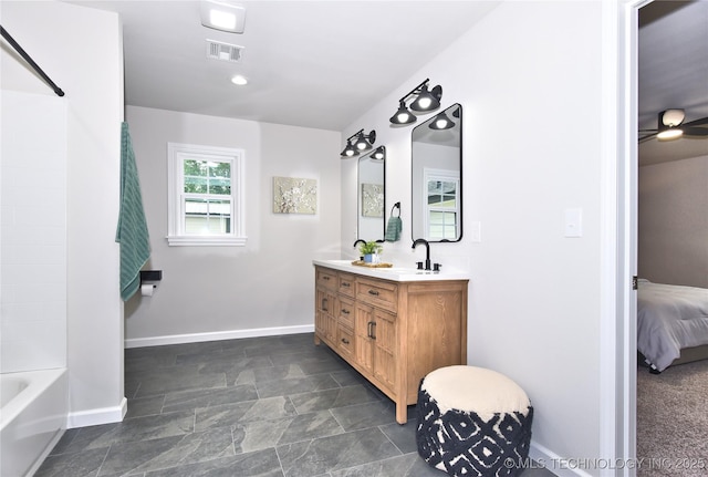 543 N Ridgeway St, Sapulpa, OK 74066 - bathroom with vanity, stone finish floors, baseboards, connected bathroom, and washtub / shower combination