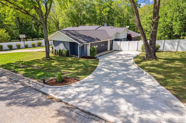 view of front of home with a front lawn, concrete driveway, and an attached garage