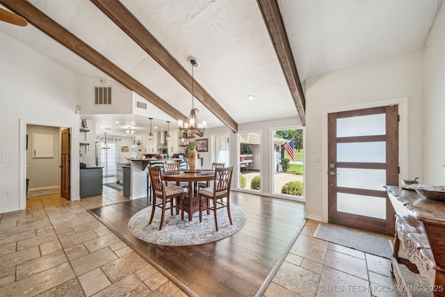dining room with an inviting chandelier, stone tile floors, baseboards, and visible vents