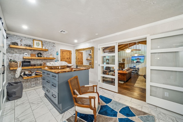 kitchen with visible vents, gray cabinetry, crown molding, and marble finish floor
