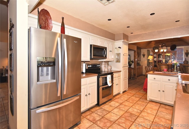 3001 Bacon Rd, Muskogee, OK 74403 - kitchen with recessed lighting, appliances with stainless steel finishes, white cabinetry, visible vents, and a notable chandelier